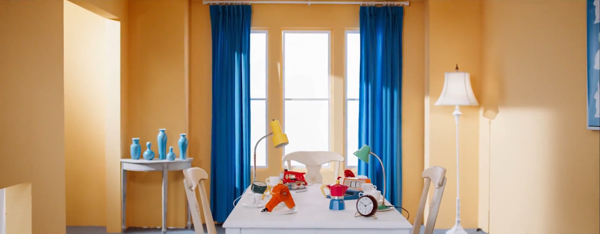 A screenshot of the yellow room with the table from before, only now the chair Heejin was sitting in is empty.