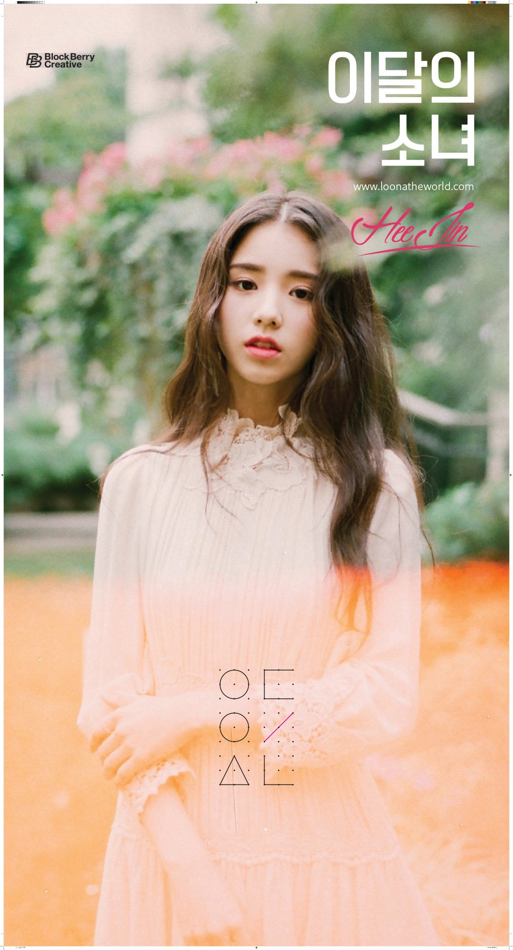 An image of Heejin. She is wearing a fancy dress and standing in a garden. She is looking at the viewer, holding one arm with the other. Her expression looks wistful.