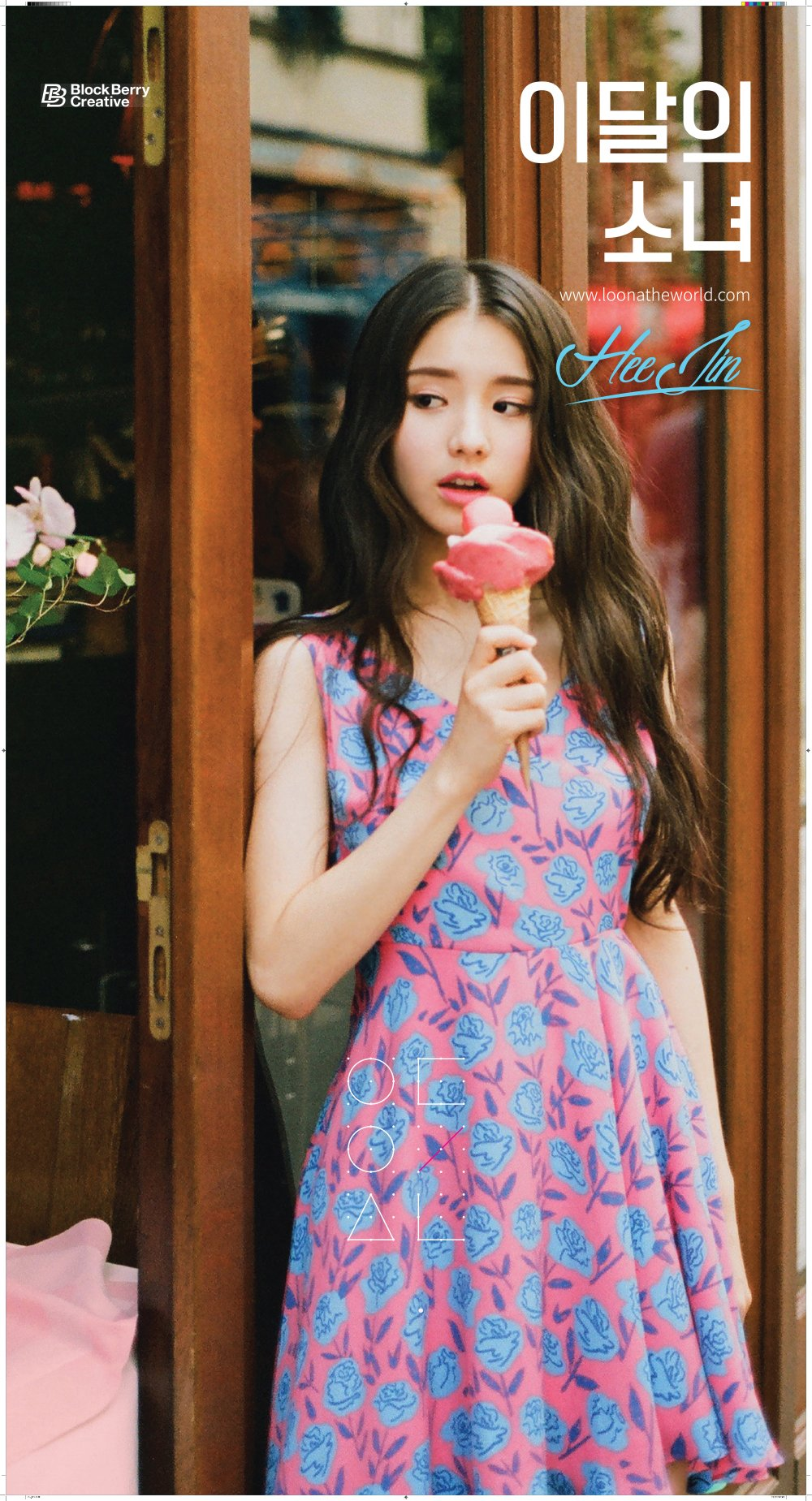 An image of Heejin. She is wearing a simple dress with a rose pattern and holding a pink ice cream cone with one hand. She is facing the viewer, with her eyes looking off to the left. Her mouth is open like she's about to eat the ice cream. Her expression looks relaxed, somewhat self-assured.