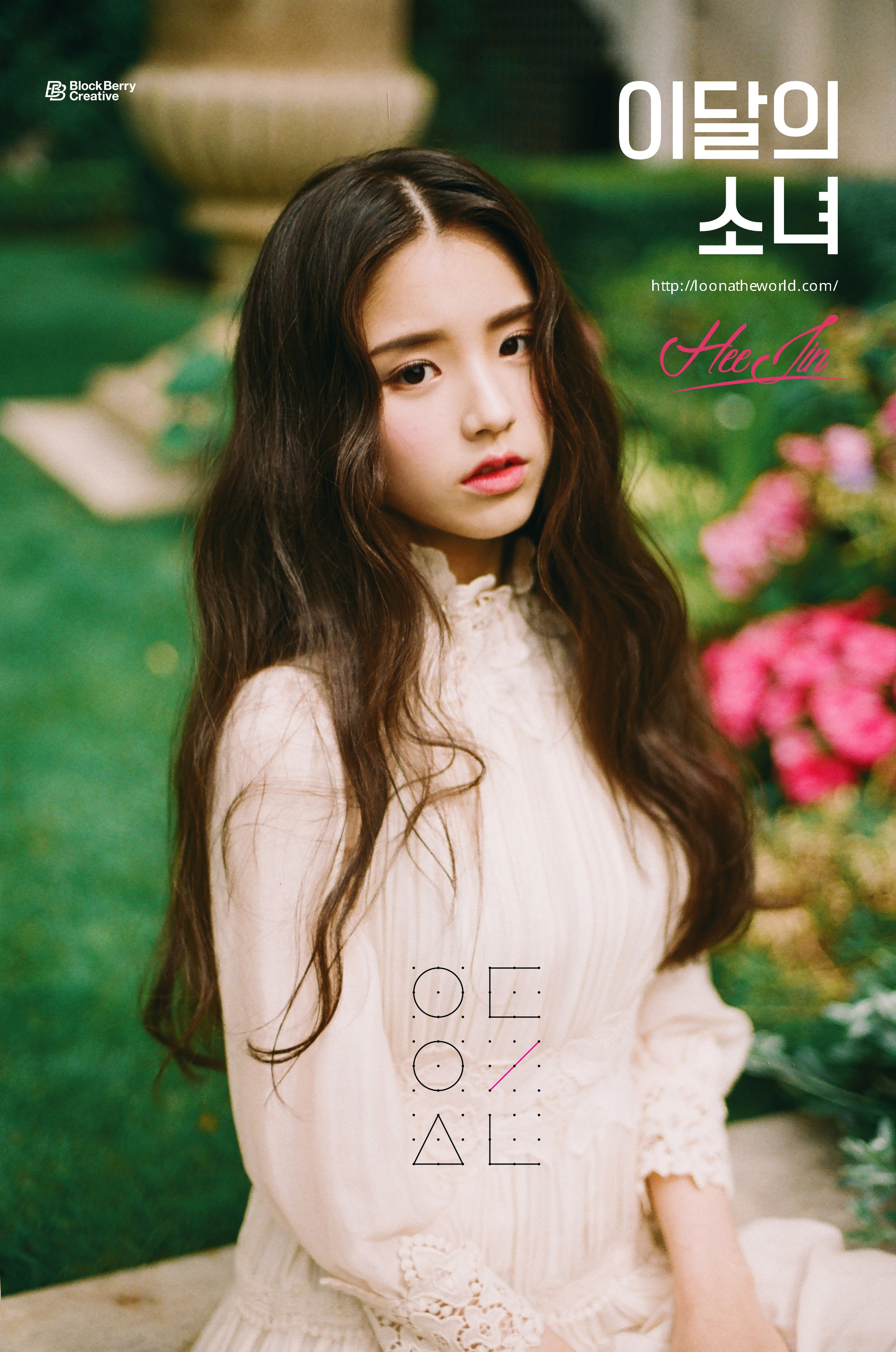 An image of Heejin. She is wearing a fancy dress and sitting in a garden. She is facing the right, with her head tilted to look at the viewer. She has a somewhat blank expression.